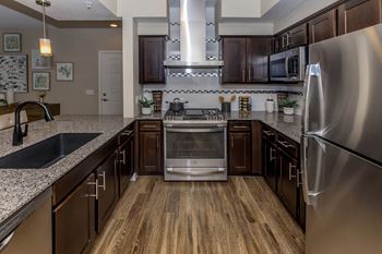 Kitchen with appliances and wooden cabinet at Level 25 at Sunset by Picerne, Las Vegas, Nevada